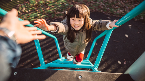 Young child being given a hand up